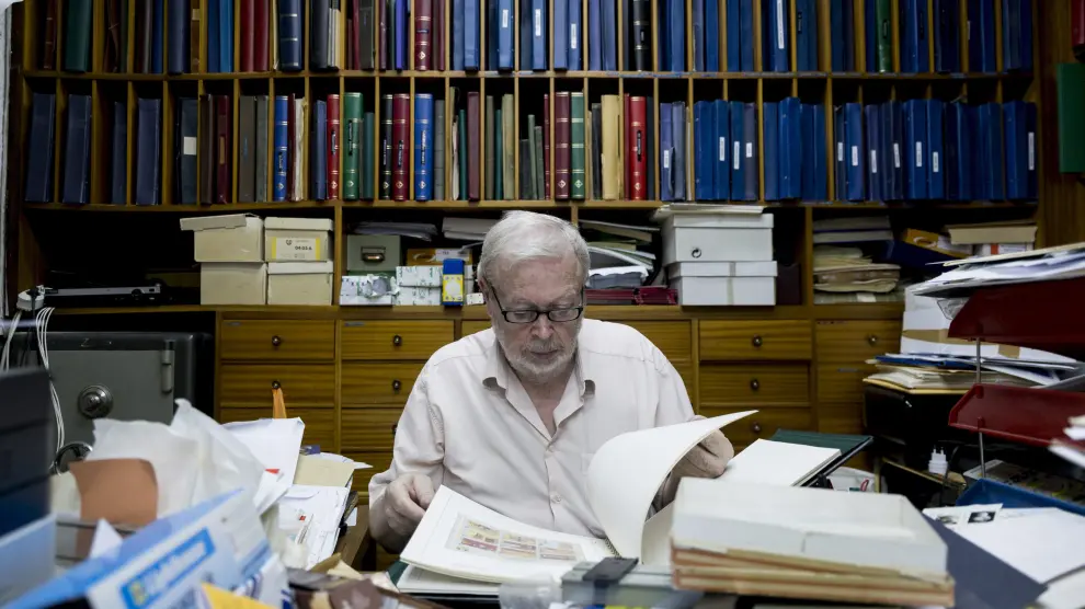 Manuel Duplá, dueño de la última filatelia de Aragón, revisa unos sellos en su despacho.