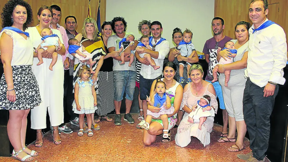 Fotografía de grupo de los niños recién nacidos con sus padres y autoridades.