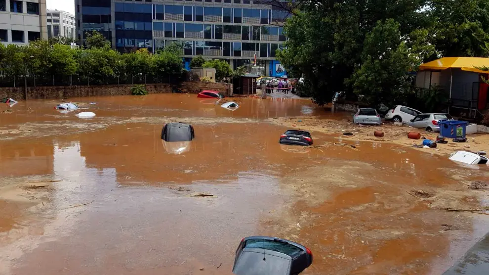 Varios vehículos han sido arrastrados por la fuertes lluvias en una calle inundada en Maroussi