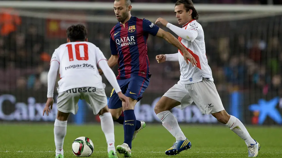 Esnáider persigue a Mascherano en el duelo de vuelta de la eliminatoria de Copa que enfrentó al Barcelona y al Huesca (de Segunda B) en diciembre de 2014.