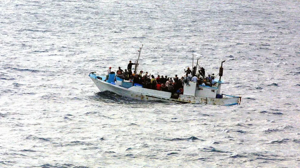 Fotografía de un barco con personas en el mar.