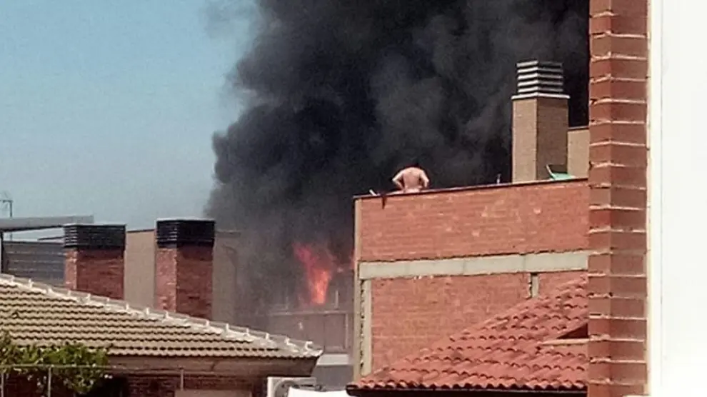 Un vecino contemplaba desde su terraza las llamas que salían de la vivienda incendiada.