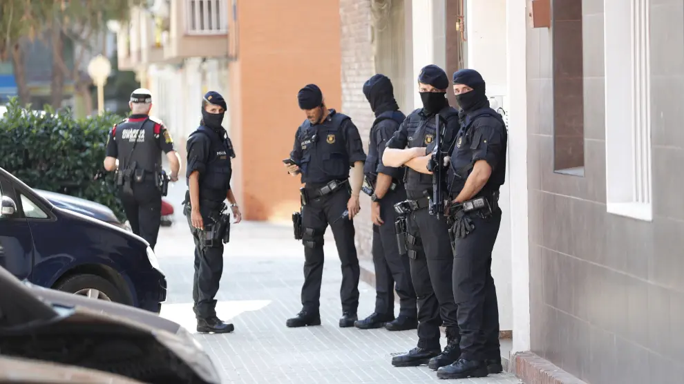 Agentes de los Mossos custodian el edificio en el que vivía el hombre abatido en la comisaría.