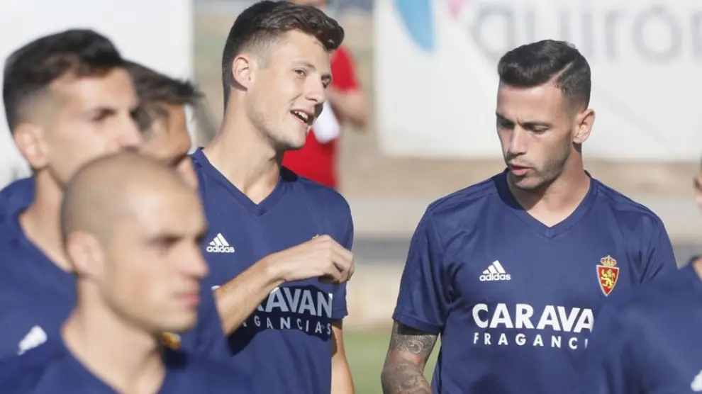 Álvaro Vázquez, a la dcha., charla con Marc Gual al inicio de su primer entrenamiento con el Real Zaragoza.