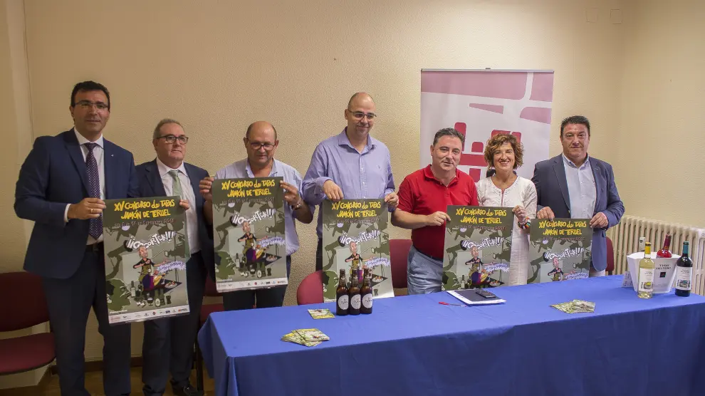 Los organizadores del concurso de tapas de jamón de Teruel, posan con el cartel anunciador.