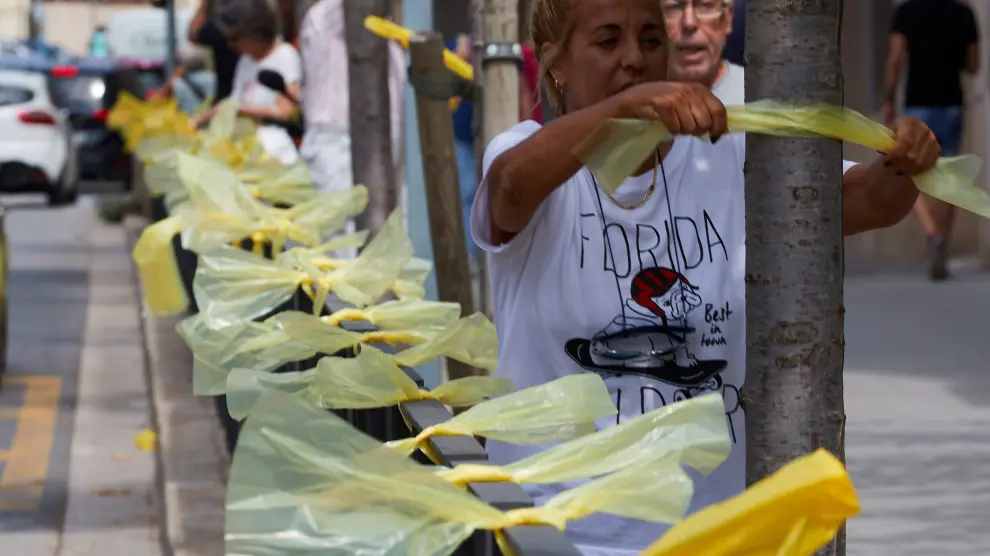 Una mujer coloca lazos amarillos en la localidad barcelonesa de Alella.