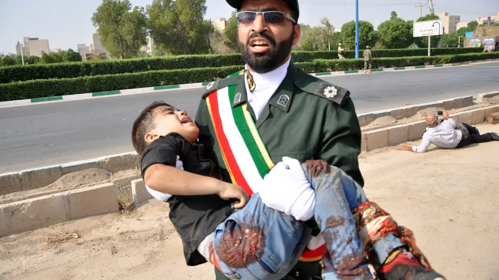 Un soldado lleva a un niño herido durante el ataque terrorista contra un desfile militar en Ahvaz (Irán) este sábado.