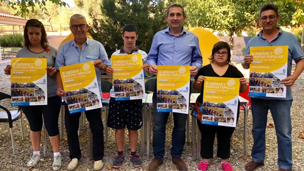 Miembros de la asociación Down Huesca muestran el cartel del evento.