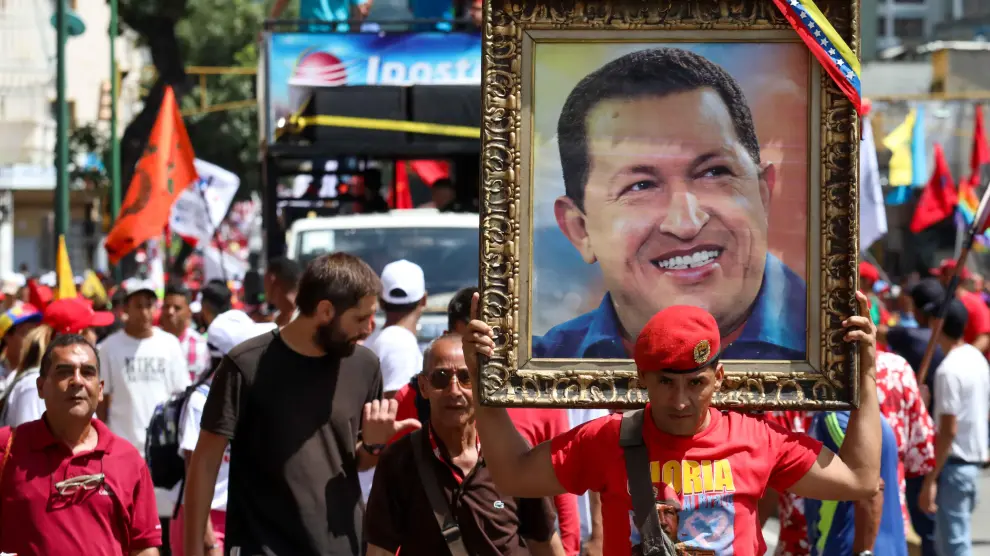 Un simpatizante del oficialismo porta un retrato de Hugo Chávez durante la marcha.