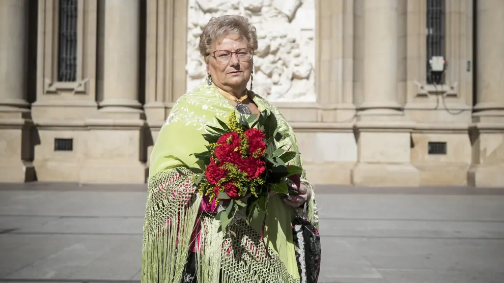 Angelines Benedi, vestida de baturra y con un ramo de claveles rojos, las mismas flores con las que se confecciona la Cruz de Lorena.