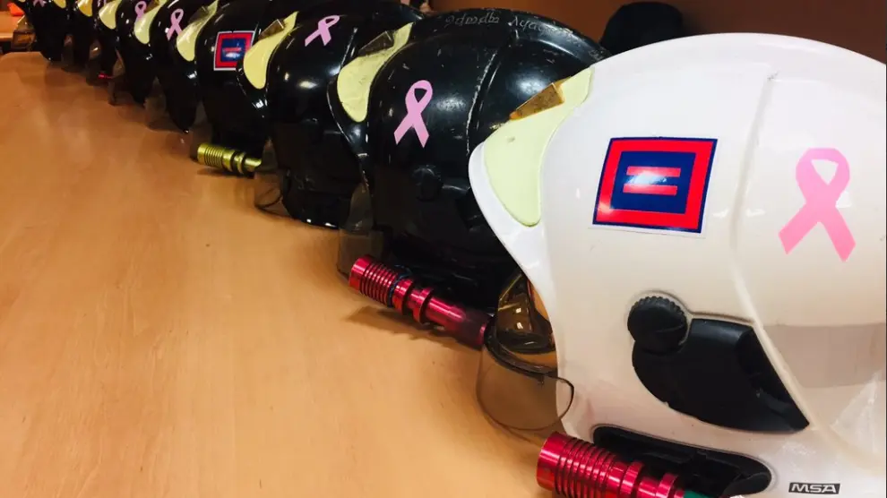 Los cascos de los bomberos de Zaragoza lucen el tradicional lazo rosa.