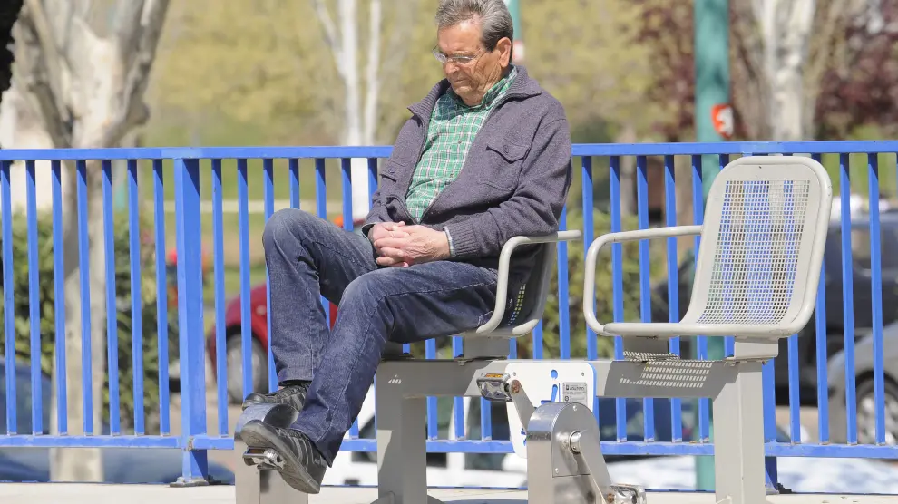 Un hombre realiza ejercicios en una aparato de pedales en un parque público.