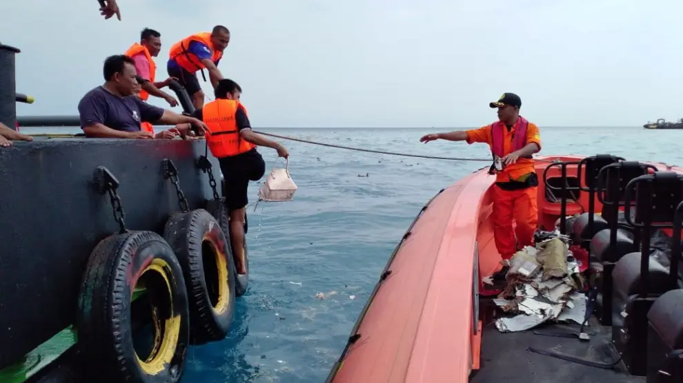 El equipo de Búsqueda y Rescate de Indonesia trabaja evacuando restos del avión en el mar de Java.