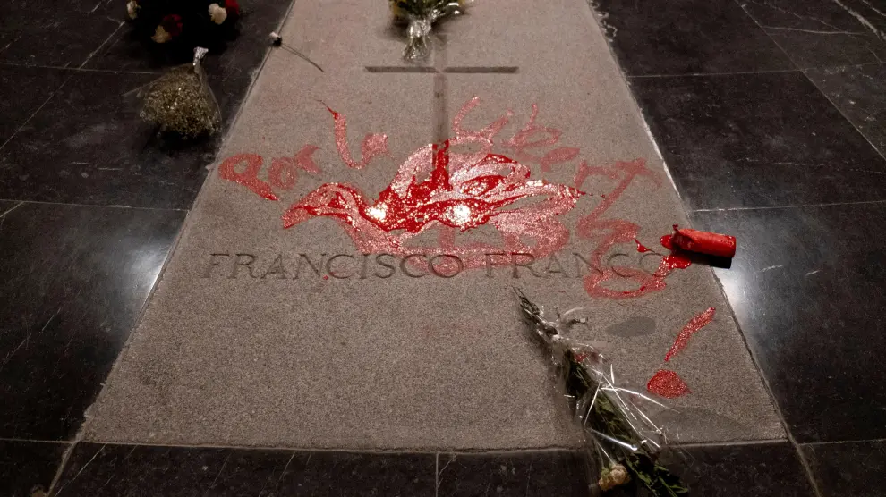 Un escultor pinta una paloma de la paz con pintura roja sobre la tumba de Franco