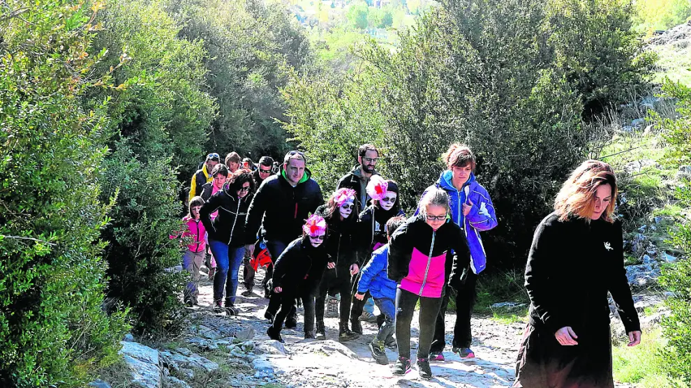 Los participantes en la visita teatralizada se dirigen hacia la Cueva de Las Güixas.