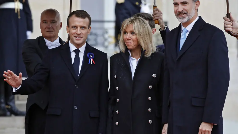 Emmanuel y Brigitte Macron, con el rey Felipe VI, este domingo en París.