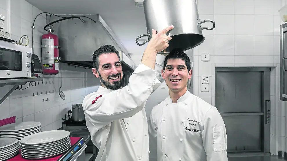 Luis Carcas izqda. bromea con su hermano Javier en las cocinas de Casa Pedro, su restaurante en Zaragoza.