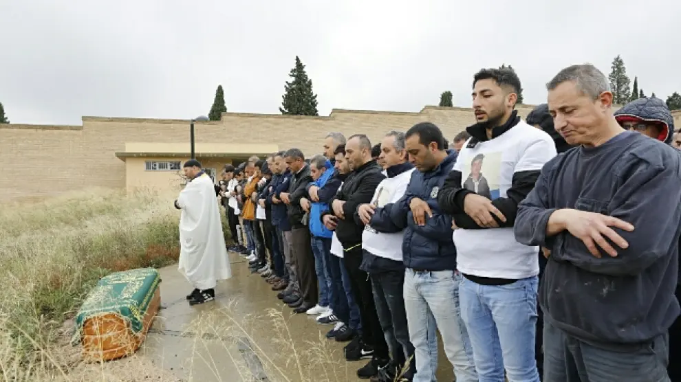Los asistentes al entierro en el cementerio musulmán de Torrero rezan en recuerdo del joven asesinado el pasado domingo.