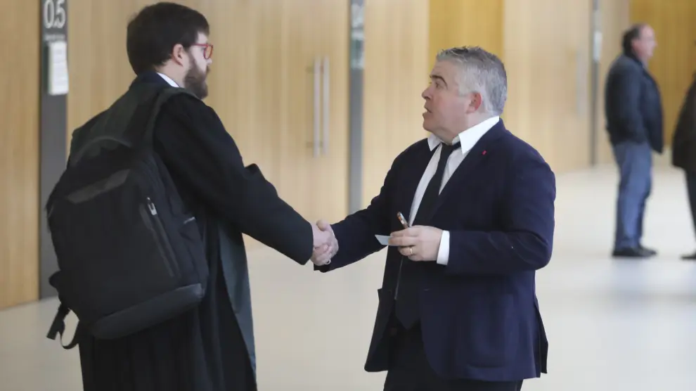 El abogado Javier Vilarrubí, a la derecha, estrecha la mano de otro de los letrados del caso tras cerrar un acuerdo entre todas las partes