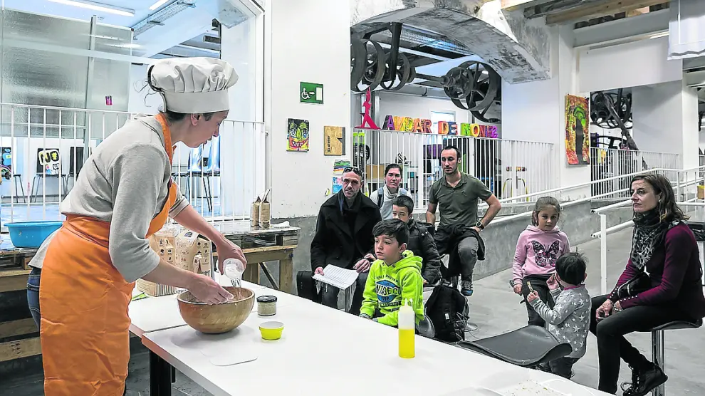 Ana Marcén, de Ecomonegros, enseña a un grupo de niños cómo hacer pan casero.