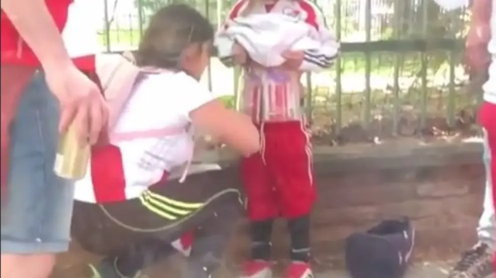 Imagen del vídeo en el que se ve a la mujer adhiriendo bengalas al cuerpo de un niño.