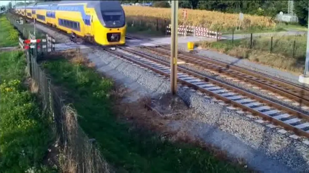 Un ciclista a punto de ser arrollado por un tren