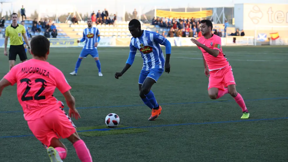 El jugador del Ejea, Moustapha, conduce el balón ante la presión de varios rivales del CD Castellón.