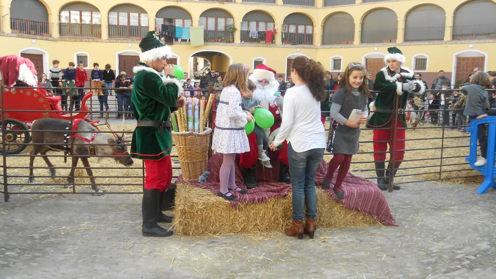 Mientras los renos descansaban, Papa Noel se ha sacado fotos con niños y mayores en la plaza de Toros Vieja