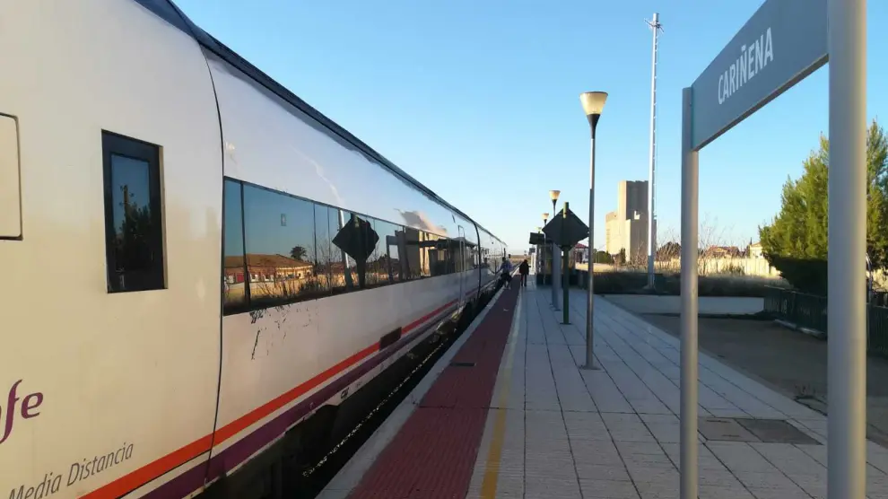 Dos viajeros suben al tren en dirección a Zaragoza en la estación de Cariñena.