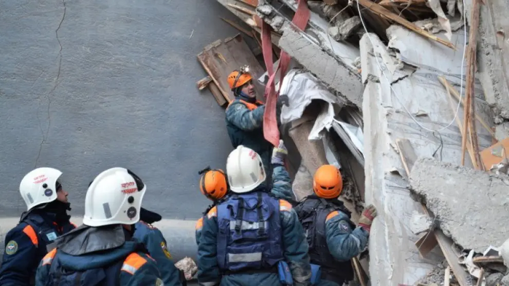 Miembros de los servicios de rescate retiran escombros del edificio derrumbado.
