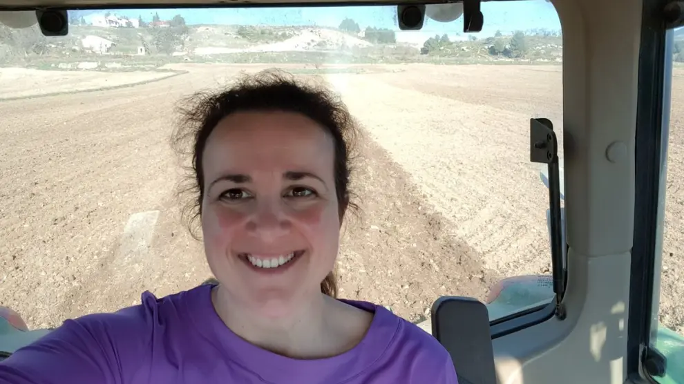 María Ángeles Rosado, joven agricultora y madre, sonríe desde su tractor.
