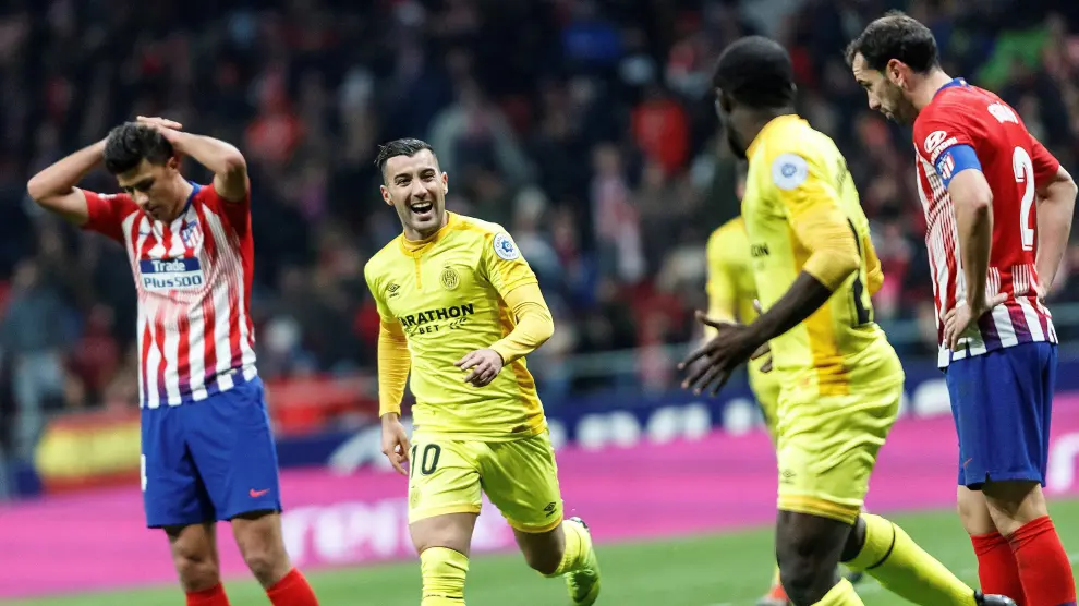 Los jugadores del Girona celebrando el pase a cuartos de final mientras Rodrigo, jugador del Atlético de Madrid, se lleva los brazos a la cabeza.