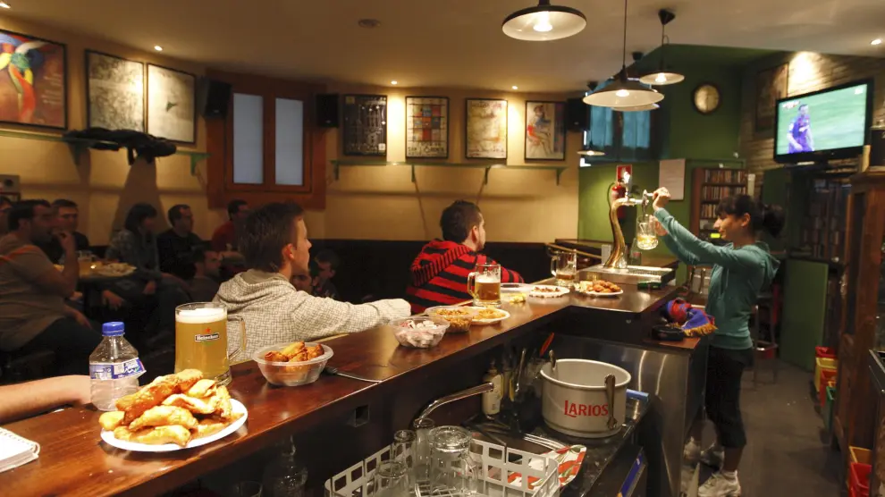 Aficionados al fútbol viendo un partido en un bar de Huesca.