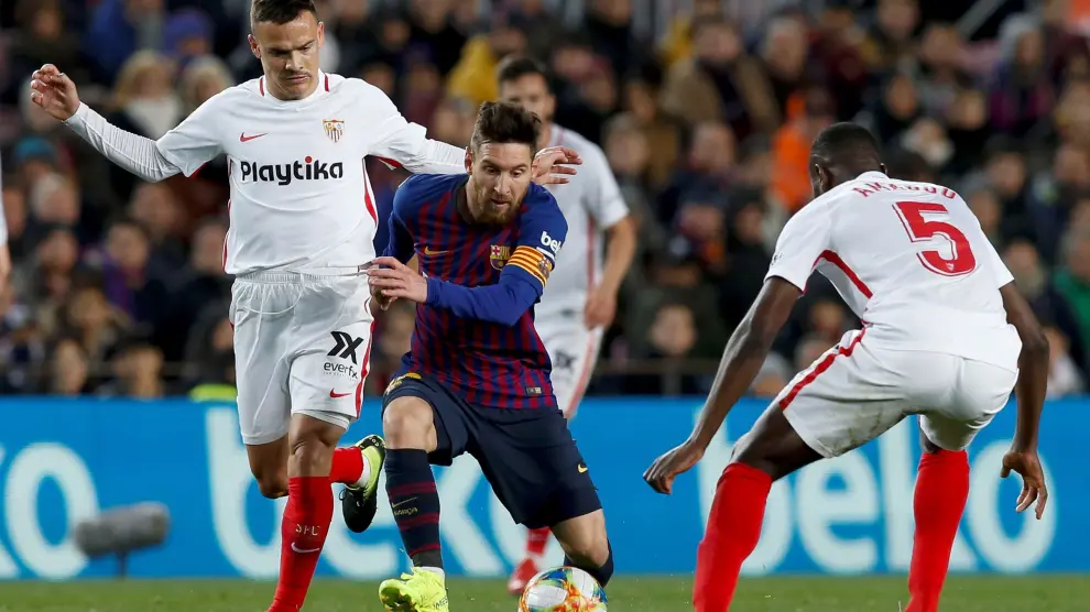 Leo Messi intenta llevarse el balón entre varios jugadores del Sevilla FC