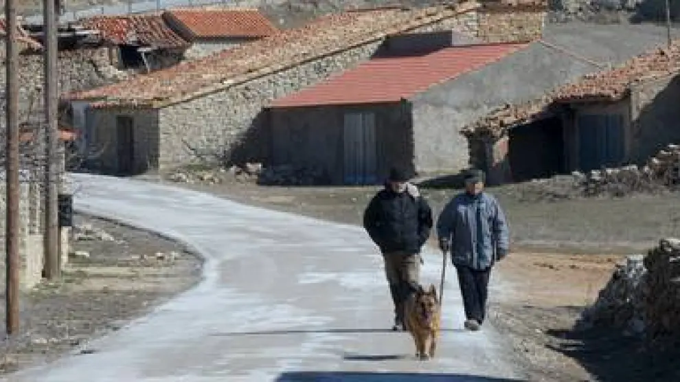 Dos hombres caminan por la carretera de Saldón, municipio turolense que solo cuenta con 10 vecinos