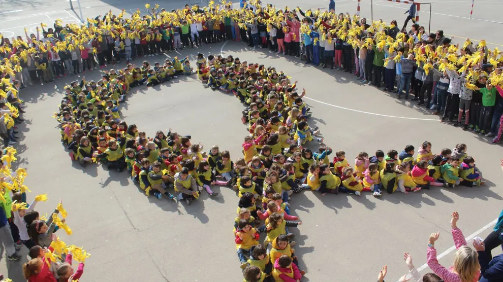 Un grupo de niños formando un lazo amarillo.