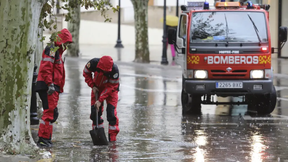 Bomberos de Huesca desatascando un desagüe durante una tromba