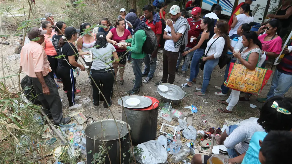 Un grupo de personas reparte comida en la frontera entre Venezuela y Colombia.
