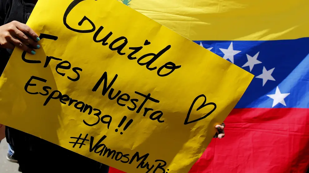 Una mujer sostiene un cartel durante una concentración de venezolanos en Colombia, donde se celebra este lunes la reunión de la cumbre del Grupo de Lima sobre Venezuela.
