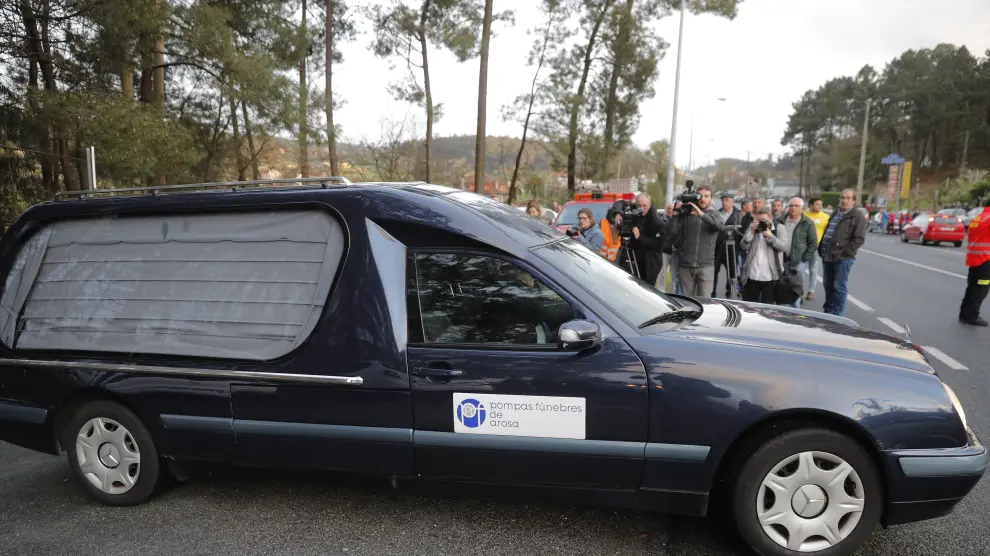 Los coches fúnebres con los dos cuerpos sin vida de un hombre de 46 años y su mujer, víctima de violencia machista, abandonan la vivienda esta tarde en la localidad de Valga (Pontevedra).