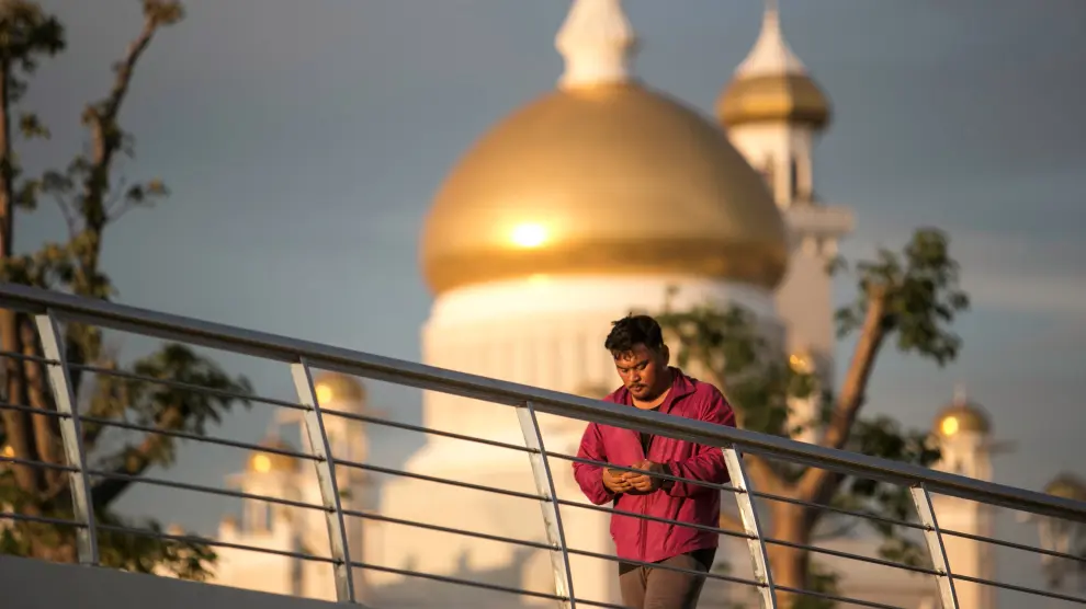 Un hombre camina frente a la mezquita del sultán Omar Ali Saifuddien, en Bandar Seri Begawan, Brunéi.