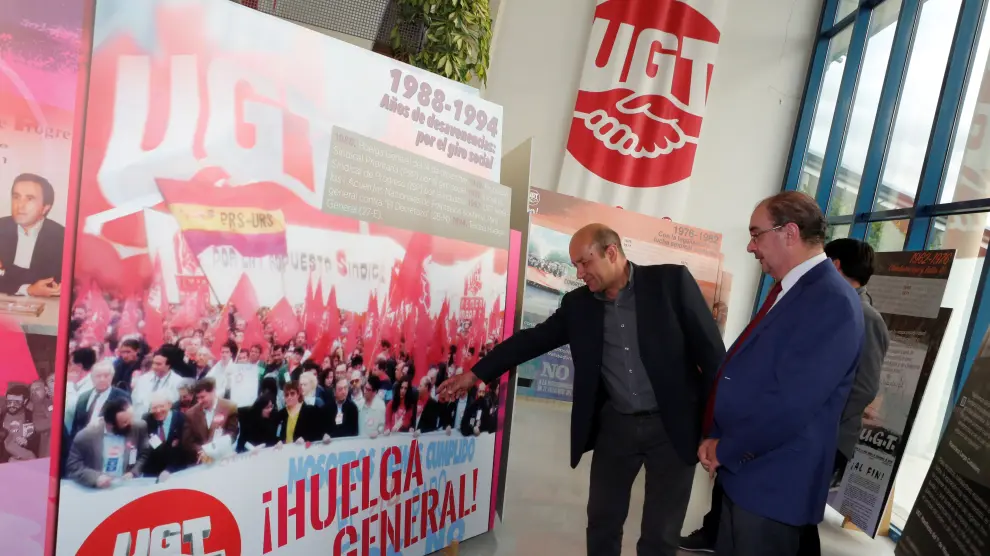 El secretario general de UGT Aragón, Daniel Alastuey, muestra a Javier Lambán, presidente del Gobierno de Aragón, imágenes de algunas de las huelgas más representativas vividas en España.