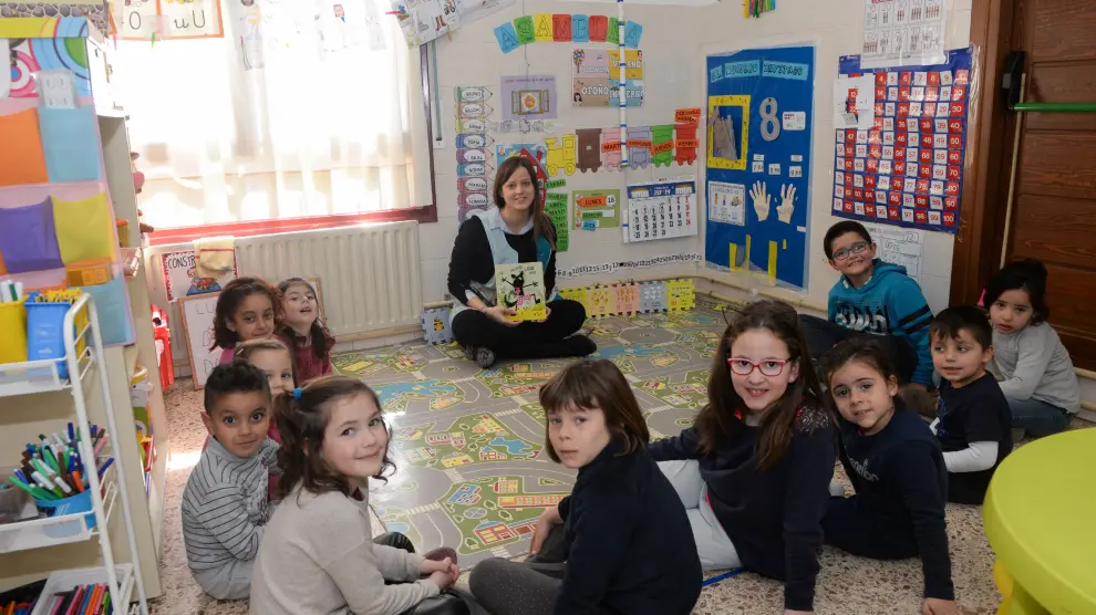 Sara Martí sentada con sus alumnos, en el aula de Valdeltormo del CRA Matarraña (Teruel), a punto de comenzar la maravillosa aventura de leer
