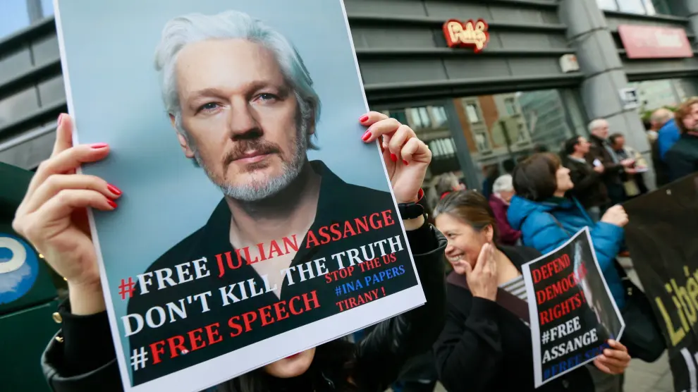 Varias personas protestan frente a la embajada británica en Bruselas para pedir la liberación de Assange.