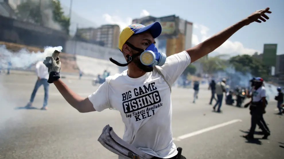 An opposition demonstrator throws back a tear gas canister on a street near the Generalisimo Francisco de Miranda Airbase "La Carlota" in Caracas, Venezuela April 30, 2019. REUTERS/Ueslei Marcelino [[[REUTERS VOCENTO]]] VENEZUELA-POLITICS/