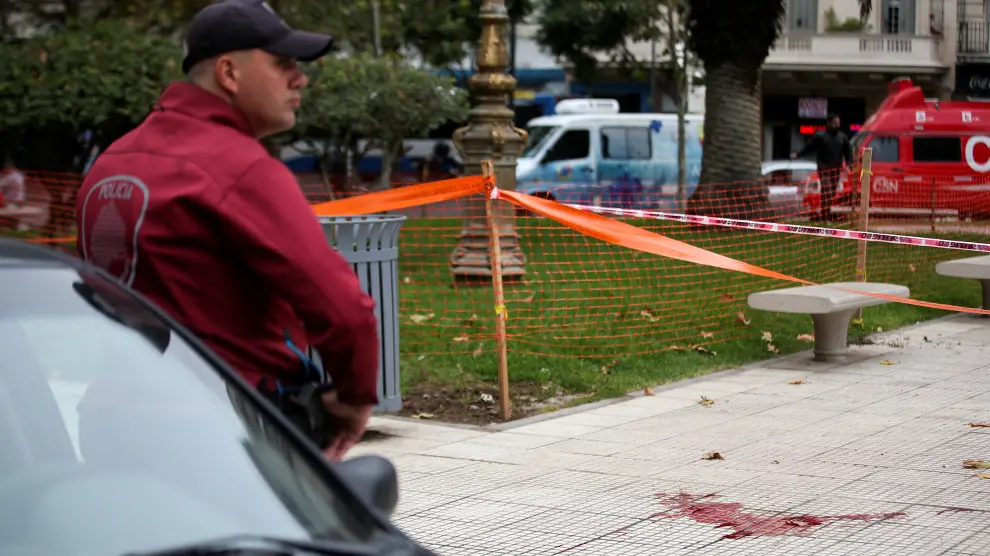 ATTENTION EDITORS - VISUAL COVERAGE OF SCENES OF INJURY OR DEATH   A police office stands next to blood on the sidewalk at the crime scene where Argentine Congressman Hector Olivares was injured and his adviser Miguel Yadon was killed in an attack near the National Congress in Buenos Aires, Argentina May 9, 2019. REUTERS/Agustin Marcarian [[[REUTERS VOCENTO]]] ARGENTINA-ATTACK/LAWMAKER