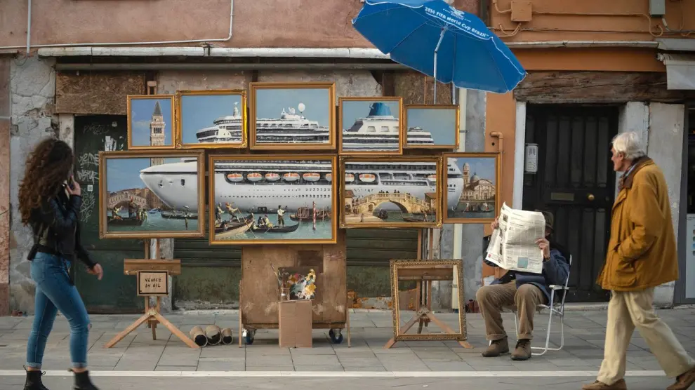 A street stall with oil paintings creating an image of a yacht in the Venice canal with a sign reading "Venice in oil", set up by a person purporting to be British artist Banksy, in Venice, Italy, May 22, 2019, in this image obtained from Banksy's social media. Courtesy of Instagram @banksy/Social Media via REUTERS. ATTENTION EDITORS - THIS IMAGE HAS BEEN SUPPLIED BY A THIRD PARTY. MANDATORY CREDIT INSTAGRAM @BANKSY. NO RESALES. NO ARCHIVES. [[[REUTERS VOCENTO]]] ART-BANKSY/VENICE-UGC