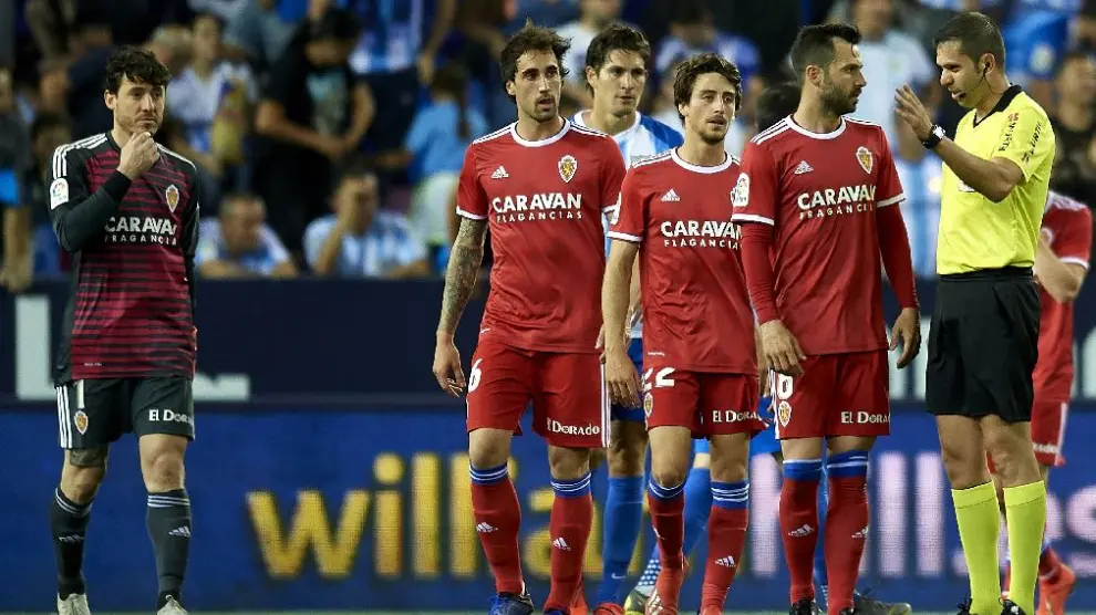 Cristian Álvarez, Eguaras, Delmás y Guitián, junto al árbitro Trujillo Suárez, en el momento de la conclusión del último partido del Real Zaragoza, en Málaga el pasado viernes, con derrota por 3-1.