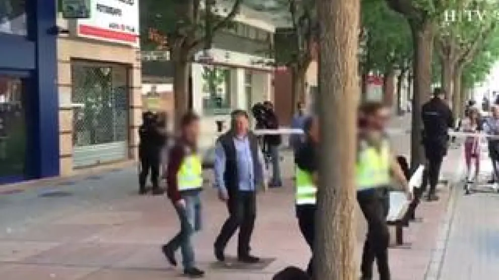 El presidente de la S.D. Huesca sale, sonriente, de la sede del club, acompañado por la Policía Nacional, tras el registro efectuado este martes.