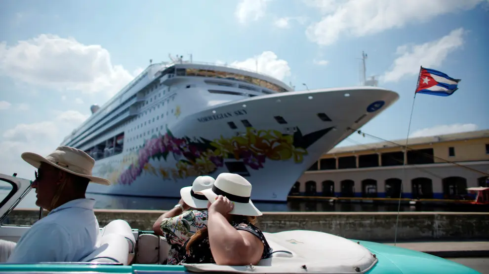 FILE PHOTO: Tourists ride inside a vintage car as they pass by the Norwegian Sky cruise ship, operated by Norwegian Cruise Lines in Havana, Cuba, May 7, 2019. Picture taken May 7, 2019. REUTERS/Alexandre Meneghini/File Photo [[[REUTERS VOCENTO]]] CUBA-USA/